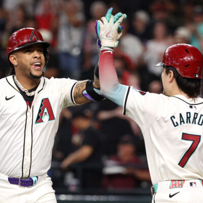 Ketel Marte of the Arizona Diamondbacks high fives Corbin Carroll after hitting a two-run home run during the fourth inning against the San Diego Padres at Chase Field.