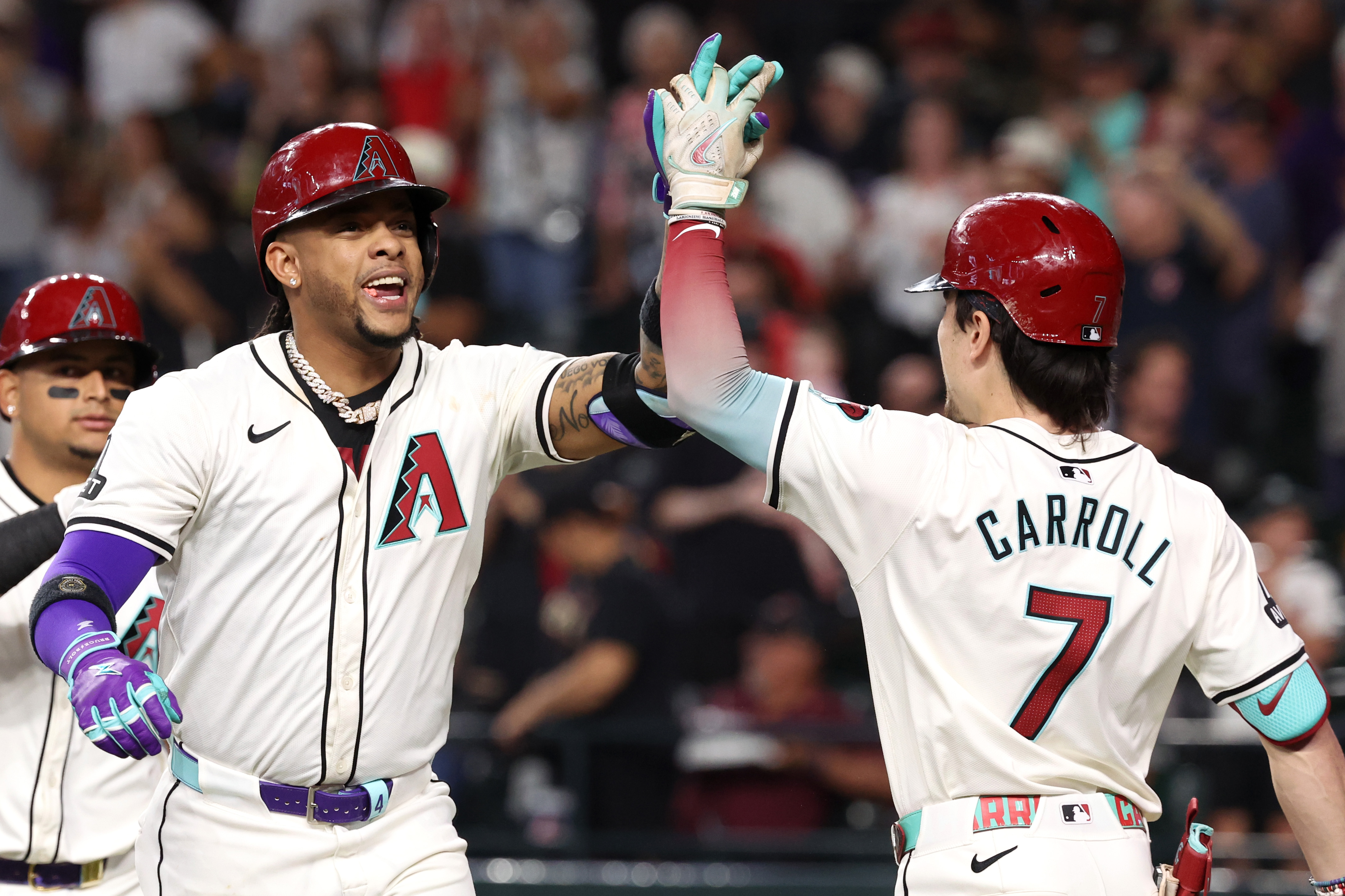 Ketel Marte of the Arizona Diamondbacks high fives Corbin Carroll after hitting a two-run home run during the fourth inning against the San Diego Padres at Chase Field.