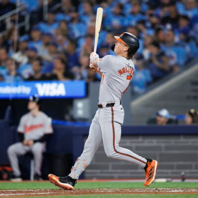 Jackson Holliday of the Baltimore Orioles hits a two-run home run to score in Eloy Jiménez #72 in the seventh inning of their MLB game against the Toronto Blue Jays at Rogers Centre.