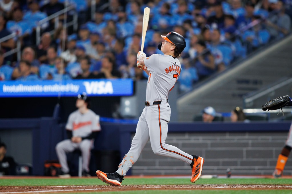Jackson Holliday of the Baltimore Orioles hits a two-run home run to score in Eloy Jiménez #72 in the seventh inning of their MLB game against the Toronto Blue Jays at Rogers Centre.