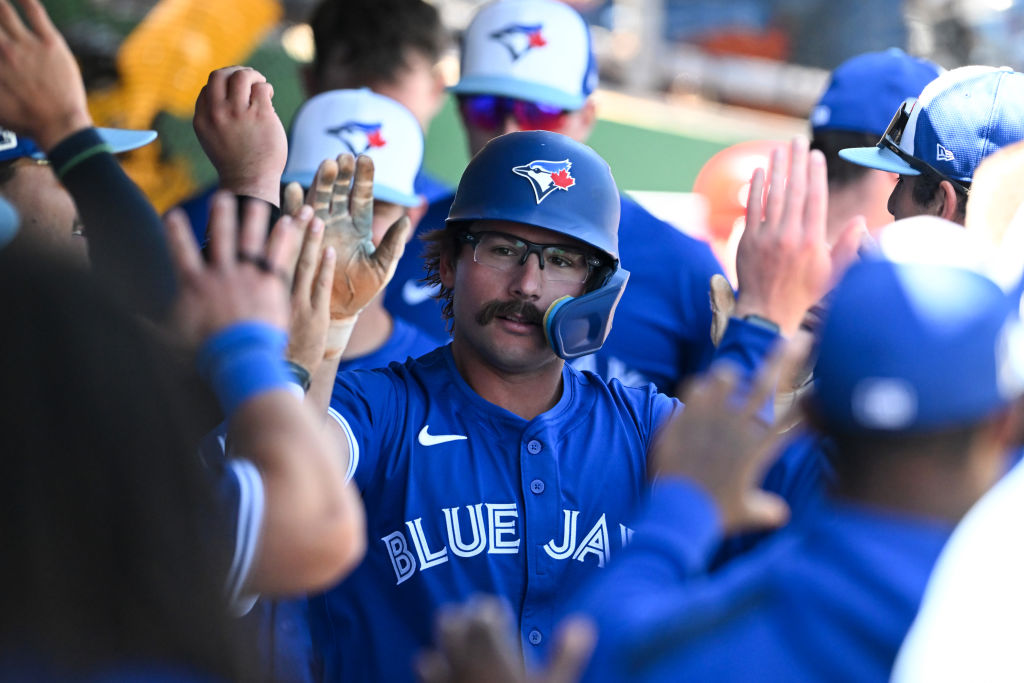 CLEARWATER, FLORIDA - MARCH 17: Davis Schneider #36 of the Toronto Blue Jays celebrates with teammates in the dugout after hitting a solo home run during the third inning of a spring training game against the Philadelphia Phillies at BayCare Ballpark on March 17, 2025 in Clearwater, Florida. (Photo by Nick Cammett/Getty Images)