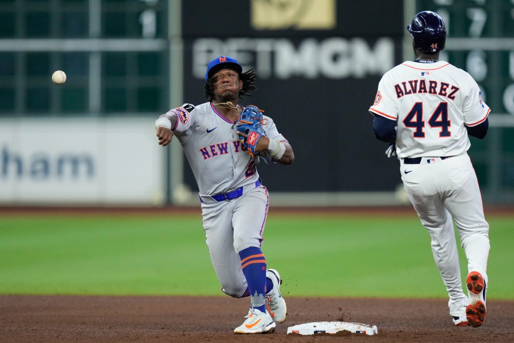 Luisangel Acuña of the New York Mets throws past Yordan Alvarez #44 of the Houston Astros for an out in the seventh inning during the game between the New York Mets and the Houston Astros at Daikin Park.