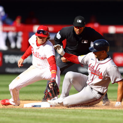 Matt Olson of the Atlanta Braves slides past Bryson Stott #5 of the Philadelphia Phillies after hitting a double during the sixth inning at Citizens Bank Park.