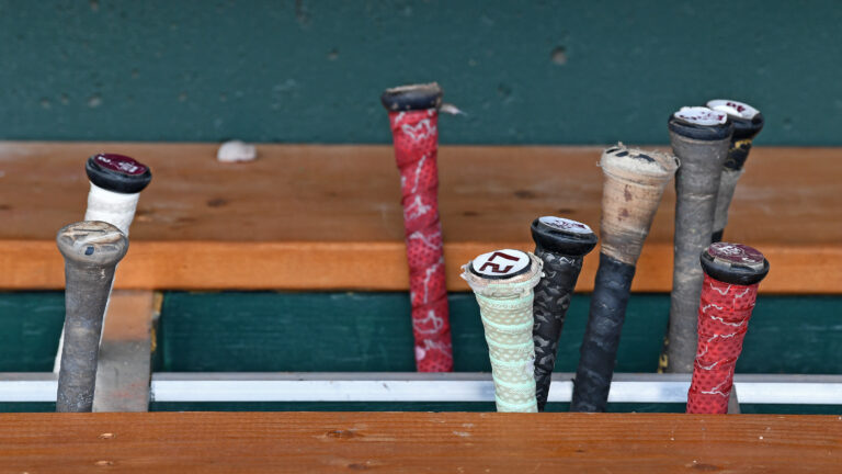 A general view Texas A&M Aggies bats in the bat rack in the dugout before the NCAA Division I Baseball Championship against the Tennessee Volunteers at Charles Schwab Field.