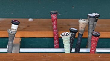 A general view Texas A&M Aggies bats in the bat rack in the dugout before the NCAA Division I Baseball Championship against the Tennessee Volunteers at Charles Schwab Field.