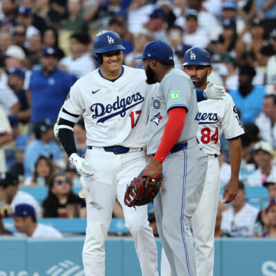 LOS ANGELES, CALIFORNIA - AUGUST 8: Shohei Ohtani #17 of the Los Angeles Dodgers is greeted at first base by Vladimir Guerrero Jr. #27 of the Toronto Blue Jays after hitting a base hit against pitcher Max Scherzer #31 during the first inning at Dodger Stadium on August 8, 2025 in Los Angeles, California. (Photo by Kevork Djansezian/Getty Images)
