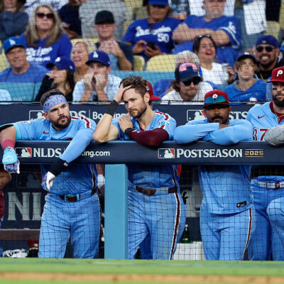 LOS ANGELES, CALIFORNIA - OCTOBER 09: Philadelphia Phillies players look on from the dugout during the 11th inning against the Los Angeles Dodgers in game four of the National League Division Series at Dodger Stadium on October 09, 2025 in Los Angeles, California. (Photo by Harry How/Getty Images)