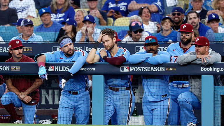 LOS ANGELES, CALIFORNIA - OCTOBER 09: Philadelphia Phillies players look on from the dugout during the 11th inning against the Los Angeles Dodgers in game four of the National League Division Series at Dodger Stadium on October 09, 2025 in Los Angeles, California. (Photo by Harry How/Getty Images)