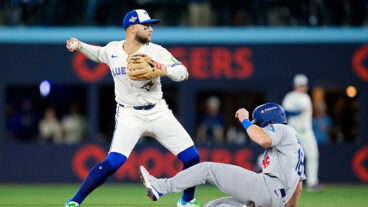 TORONTO, ONTARIO - OCTOBER 24: Bo Bichette #11 of the Toronto Blue Jays throws to first base late after forcing out Will Smith #16 of the Los Angeles Dodgers at second base in game one of the 2025 World Series at Rogers Center on October 24, 2025 in Toronto, Ontario. (Photo by Mark Blinch/Getty Images)
