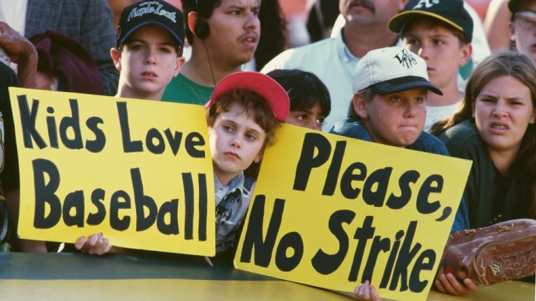 General view of young baseball fans holding up signs protesting against the proposed strike by the Major League Baseball Players Association during the Major League Baseball American League West game between the Oakland Athletics and the Seattle Mariners on 11th August 1994 at the Oakland-Alameda County Coliseum in Oakland, California, United States. The strike began on 12th August 1994, and resulted in the remainder of that season being canceled, including the postseason and, for the first time since 1904, the World Series. The strike was suspended on 2nd April 1995, after 232 days, making it the longest such stoppage in MLB history. (Photo by Otto Greule Jr/Allsport/Getty Images)