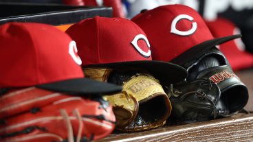 MIAMI, FL - APRIL 07: Cincinnati Reds caps and gloves rest in the dugout during the game between the Cincinnati Reds and the Miami Marlins on Tuesday. APril 7, 2026 at LoanDepot Park in Miami, FL (Photo by Peter Joneleit/Icon Sportswire via Getty Images)