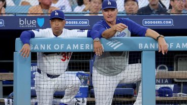 LOS ANGELES, CALIFORNIA - AUGUST 12: Manager Dave Roberts #30 and Bob Geren #88 of the Los Angeles Dodgers talk in the dugout during the first inning against the Kansas City Royals at Dodger Stadium on August 12, 2026 in Los Angeles, California. (Photo by Katelyn Mulcahy/Getty Images)