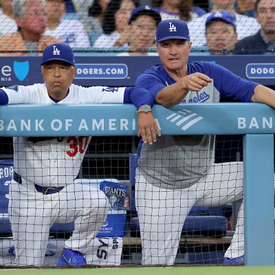 LOS ANGELES, CALIFORNIA - AUGUST 12: Manager Dave Roberts #30 and Bob Geren #88 of the Los Angeles Dodgers talk in the dugout during the first inning against the Kansas City Royals at Dodger Stadium on August 12, 2026 in Los Angeles, California. (Photo by Katelyn Mulcahy/Getty Images)