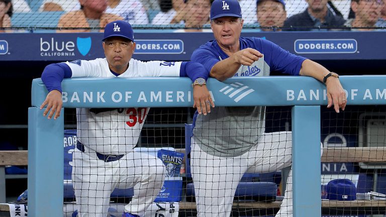 LOS ANGELES, CALIFORNIA - AUGUST 12: Manager Dave Roberts #30 and Bob Geren #88 of the Los Angeles Dodgers talk in the dugout during the first inning against the Kansas City Royals at Dodger Stadium on August 12, 2026 in Los Angeles, California. (Photo by Katelyn Mulcahy/Getty Images)